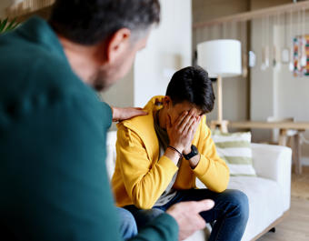 Worried Man Being Comforted By A Colleague