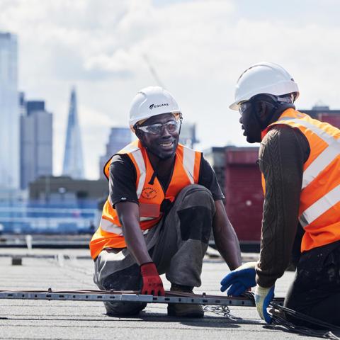 Two construction workers on rooftop