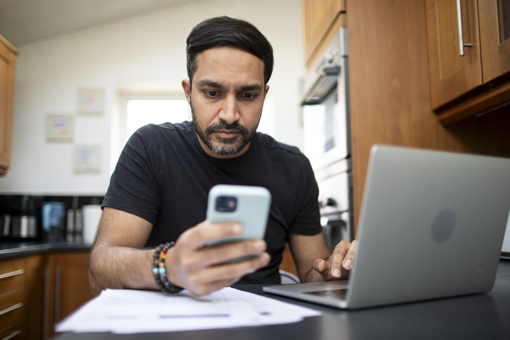 Asian Man Checking Finances On Phone