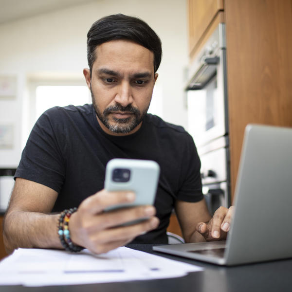 Asian Man Checking Finances On Phone