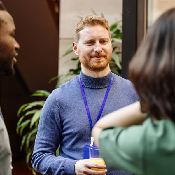 Smiling business man talking to colleagues during a coffee break
